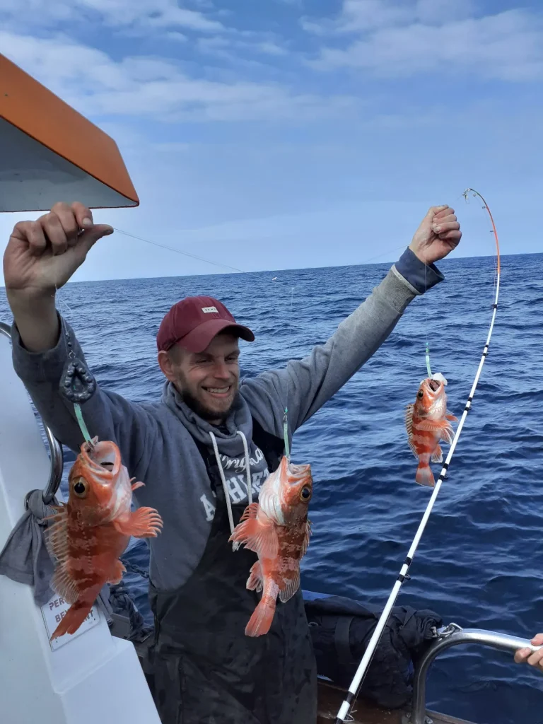 Angler holding a fish up to a blue sky
