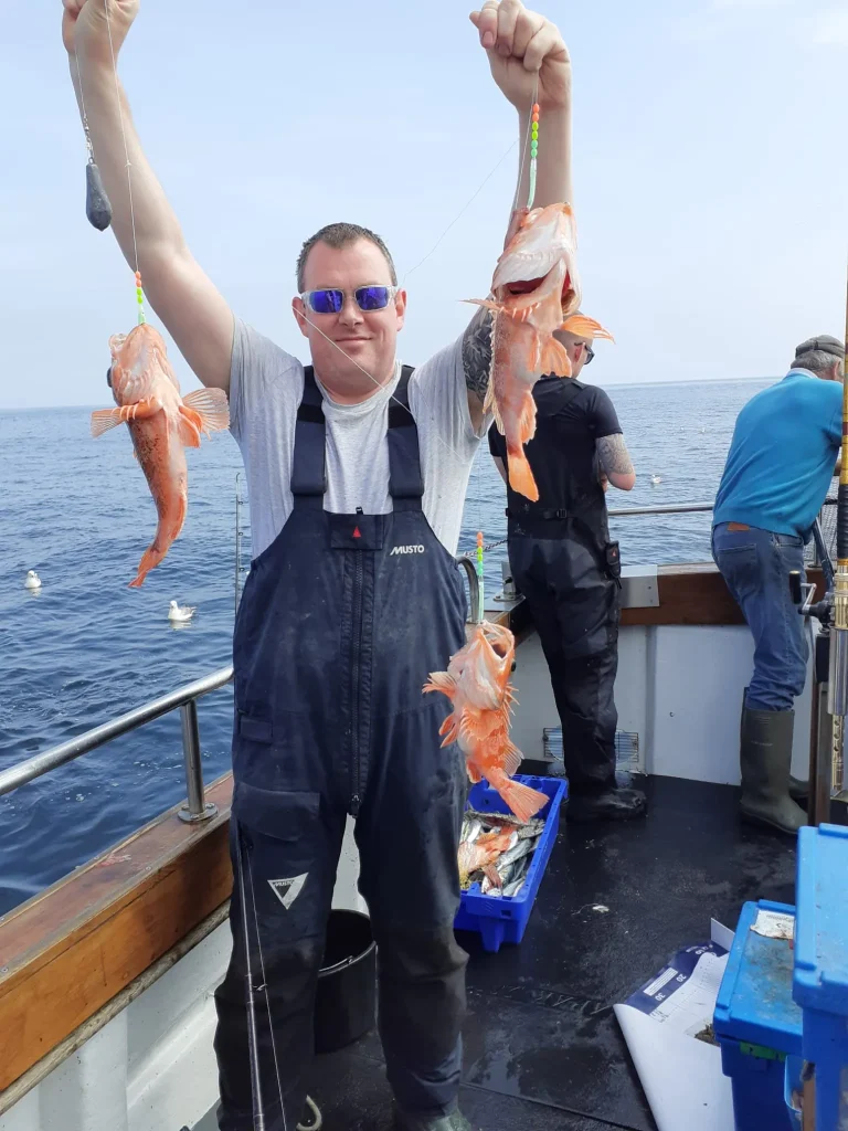melissa-askew-a1n1yPxHoIM-unsplash Angler holding up two red fish