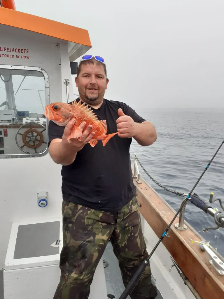 Happy angler giving a thumbs up with a red fish