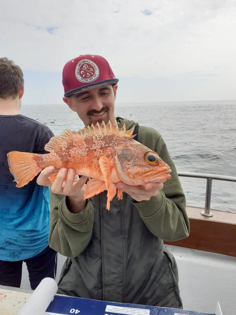 Home Angler holding a big red fish