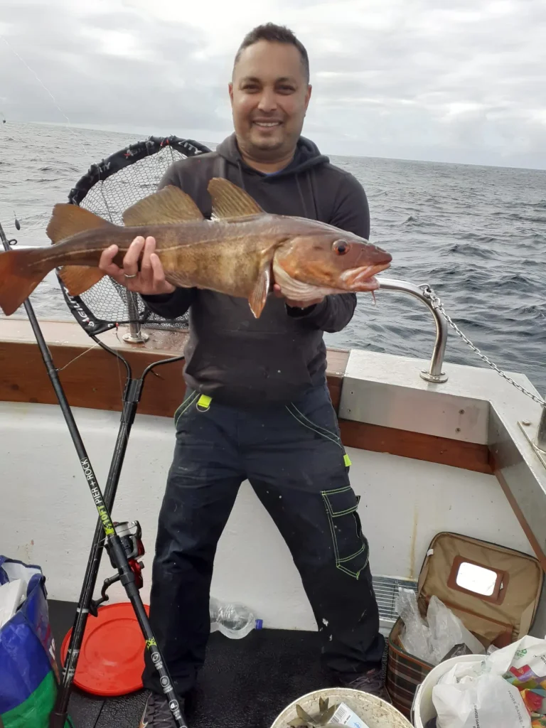 sean-oulashin-KMn4VEeEPR8-unsplash Angler holding a large fish on deck