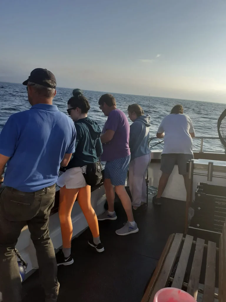 Home Anglers lined up at the rail on a sea fishing trip