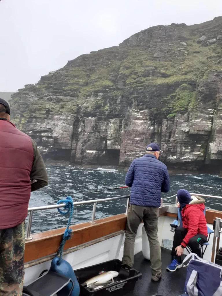 Anglers fishing beneath sea cliffs off South Kerry
